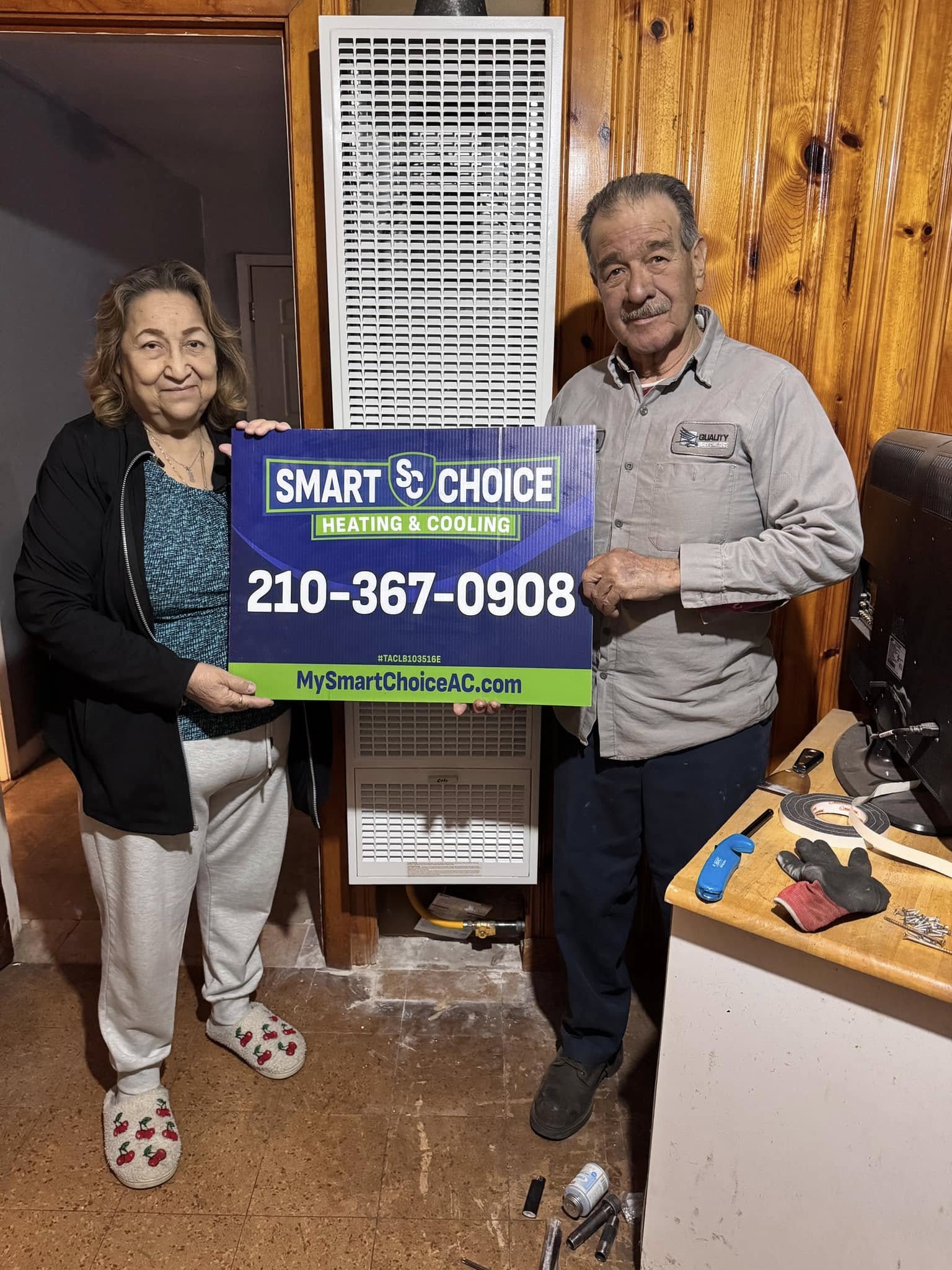 Happy customer standing by a new outdoor AC unit holding a Smart Choice sign.