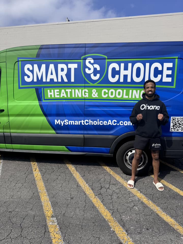 Two customers indoors holding a Smart Choice sign by their heater.